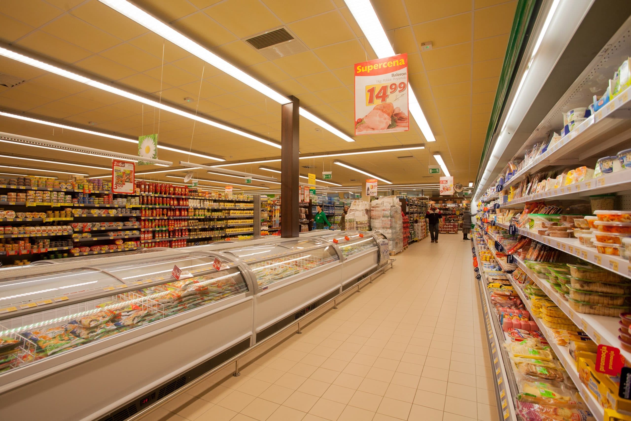 Oświetlenie LED skierowane wzdłuż alejek z chłodniami i regałami w sklepie Stokrotka